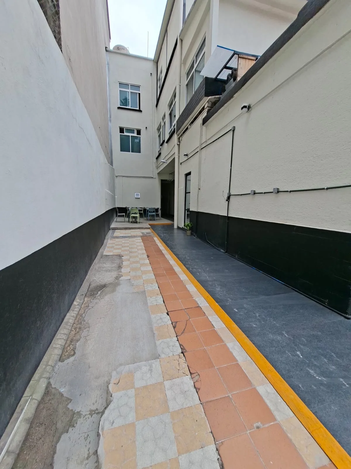 Acceso exterior con pasillo, rampa y muros blancos